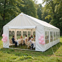 White party tent with pink balloons in a park setting