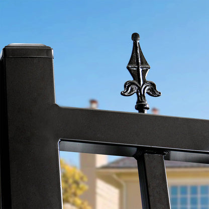 Black metal fence post with decorative top finial against a clear blue sky.