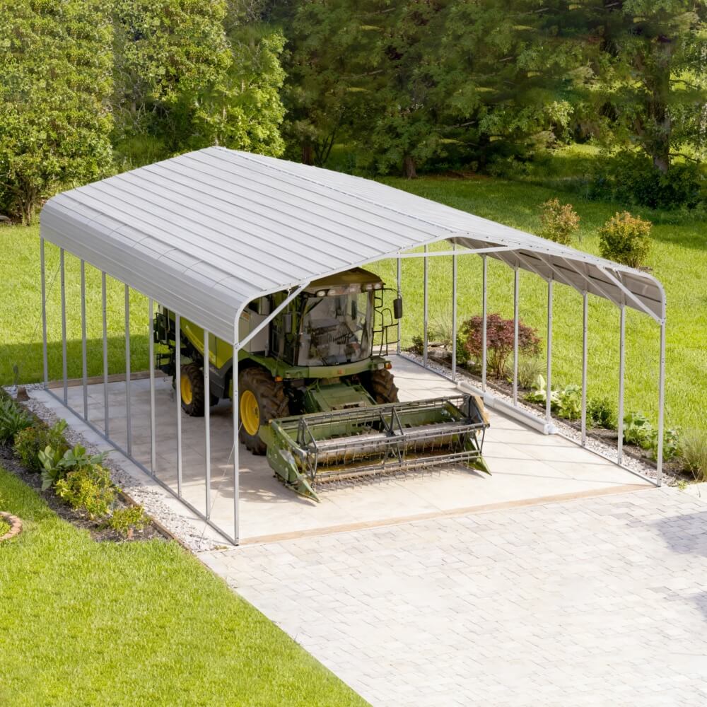 Metal carport with a tractor inside on a grassy area