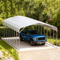 Blue truck parked under a metal carport with trees in the background