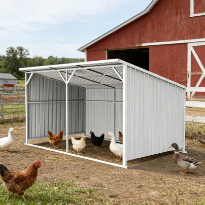 White metal chicken coop with chickens and ducks in front of a red barn.