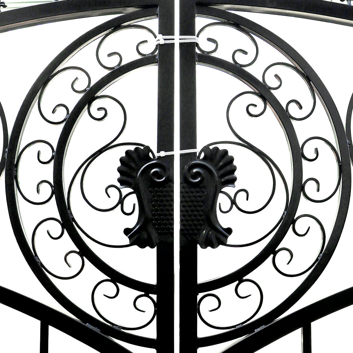 Black wrought iron gate with ornate scrollwork and decorative finials