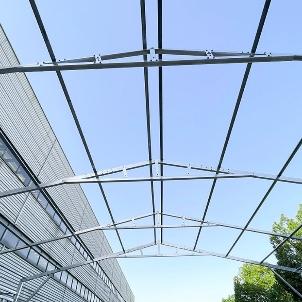 Glass roof structure with metal framework against a blue sky#color_White
