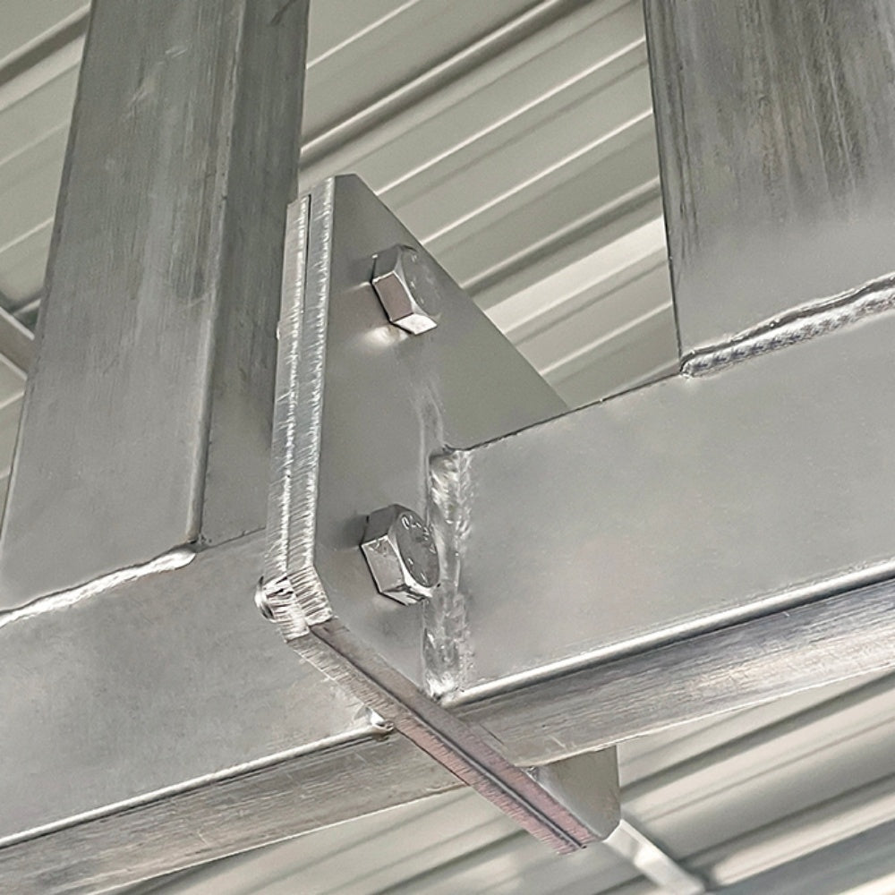 Close-up of metal beams and brackets in a construction setting#color_White