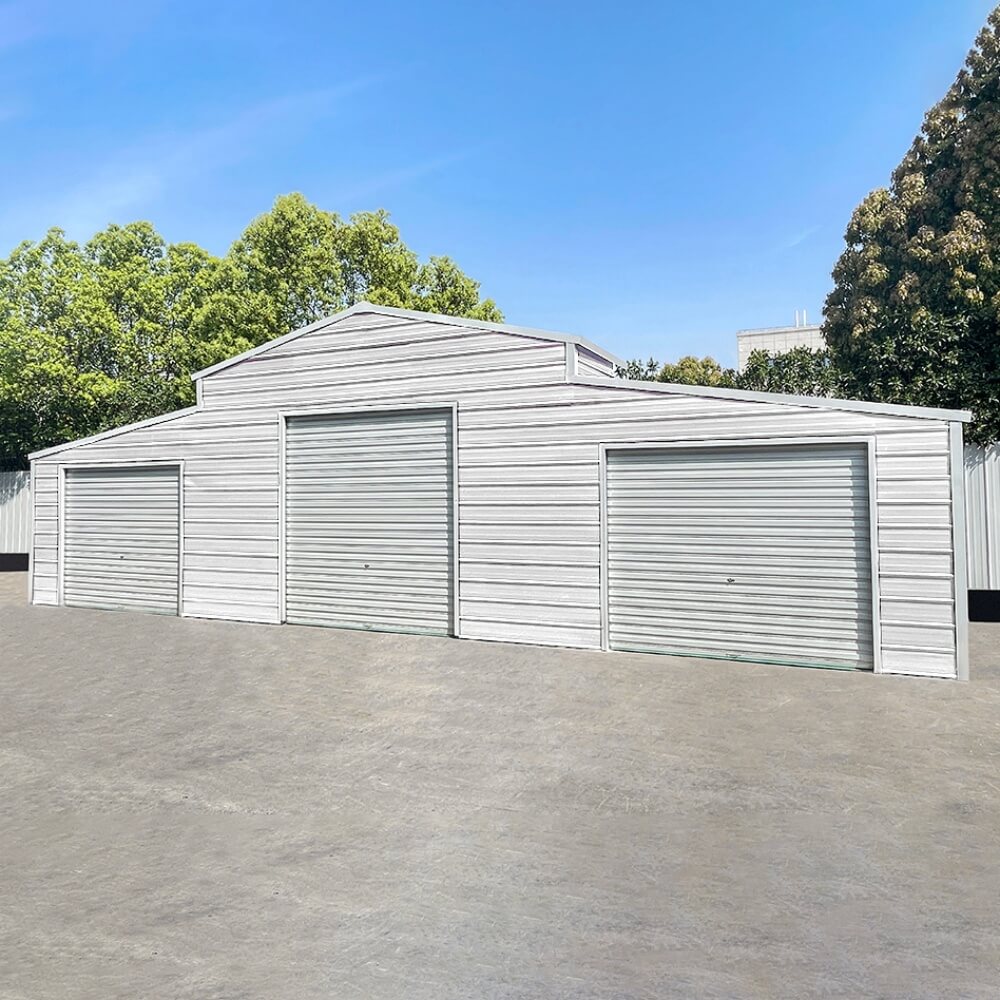 White metal garage with three doors on a clear day