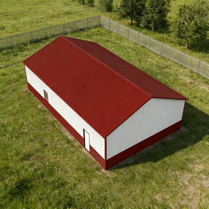 Red and white barn on a grassy field with trees in the background