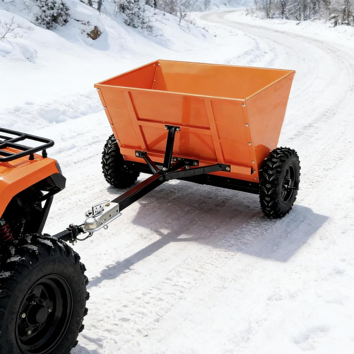 Orange dump trailer attached to a vehicle on a snowy road