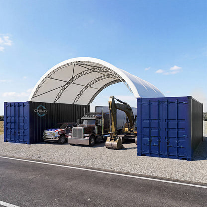 Large white tent structure with blue shipping containers and a truck underneath on a clear day.