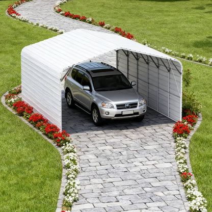 Car parked inside a white portable garage on a grassy area with a paved pathway.