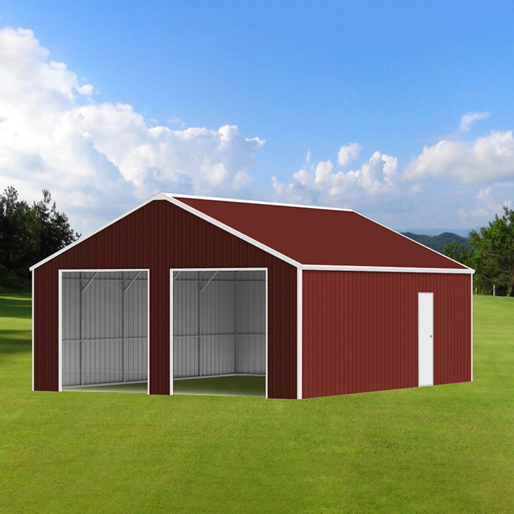 Red metal barn with white doors on a grassy field under a blue sky.