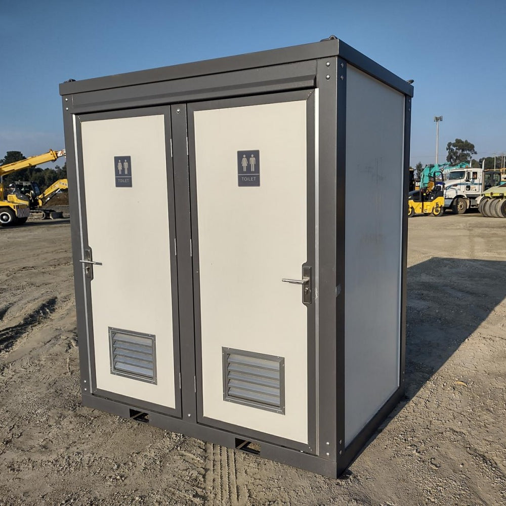 A portable outdoor restroom enclosure with two cream-colored doors and a dark gray metal frame