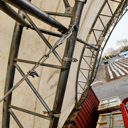 Metal scaffolding structure with a container and boxes in the background