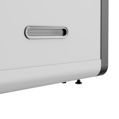 Close-up of a white electronic device with a speaker grille on a light gray background