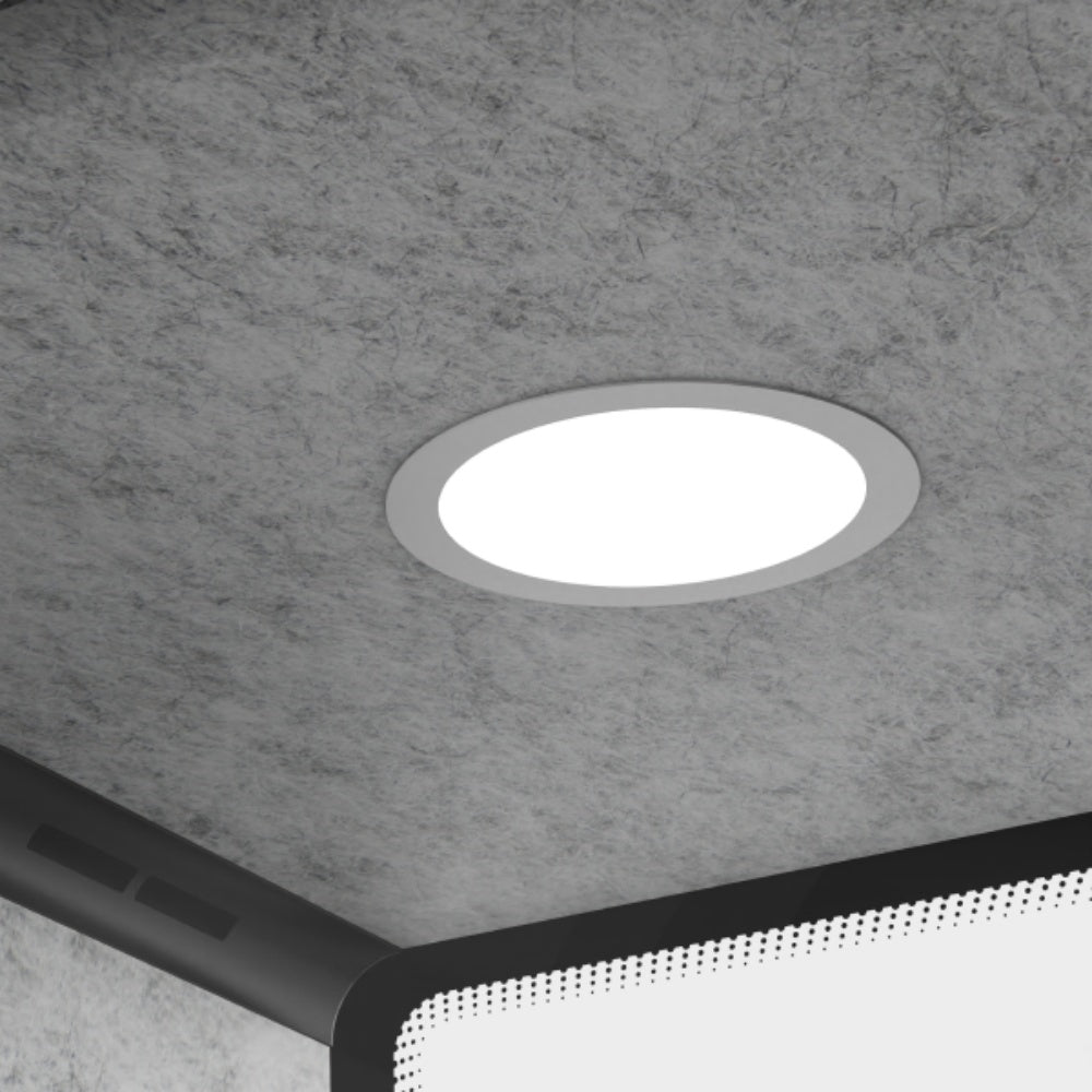 Round recessed ceiling light fixture on a gray concrete ceiling