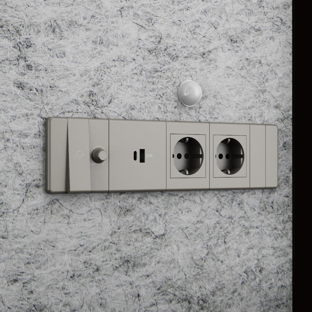 Wall-mounted electrical socket with two sockets and a switch on a marble wall.