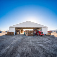 W60'xL40'xH9' Steel Shipping Container Roof Kit, surrounded by stacked wooden pallets and boxes on the dirt ground.