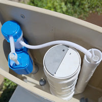 Water filter system with blue cap and white hose attached to a beige container.