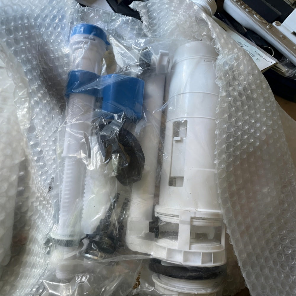 Plumbing parts in packaging on a bubble-wrapped surface